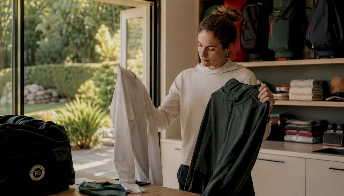Golfer selecting layered golf clothing indoors