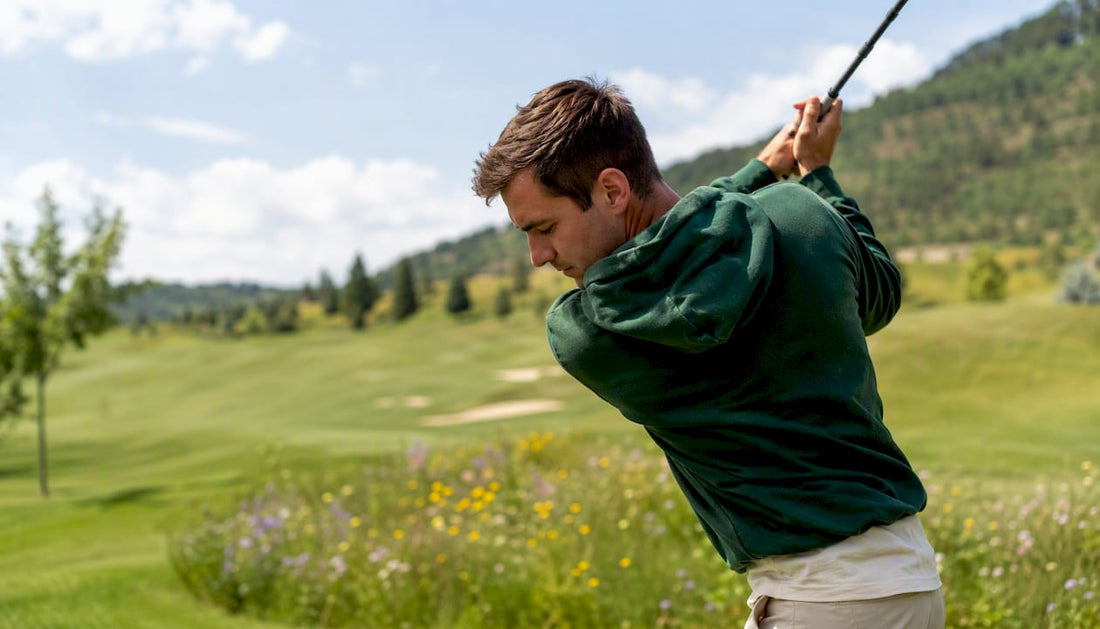 Golfer mid-swing in bold jewel-toned hoodie