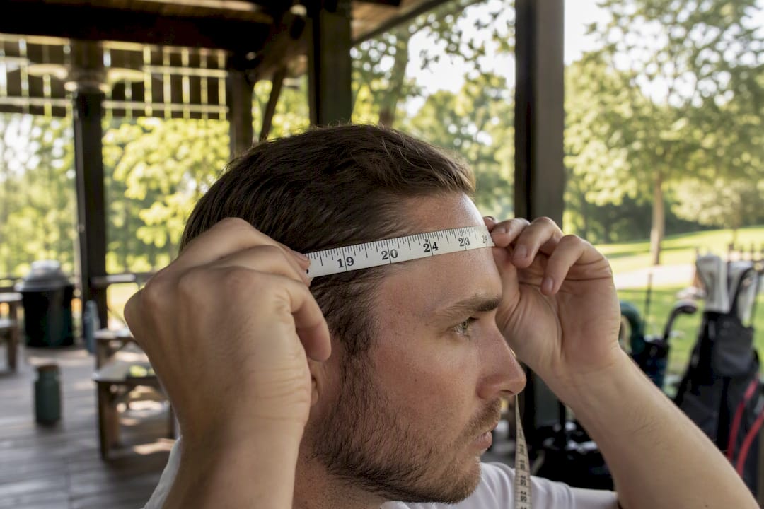Hand measuring head circumference with tape measure