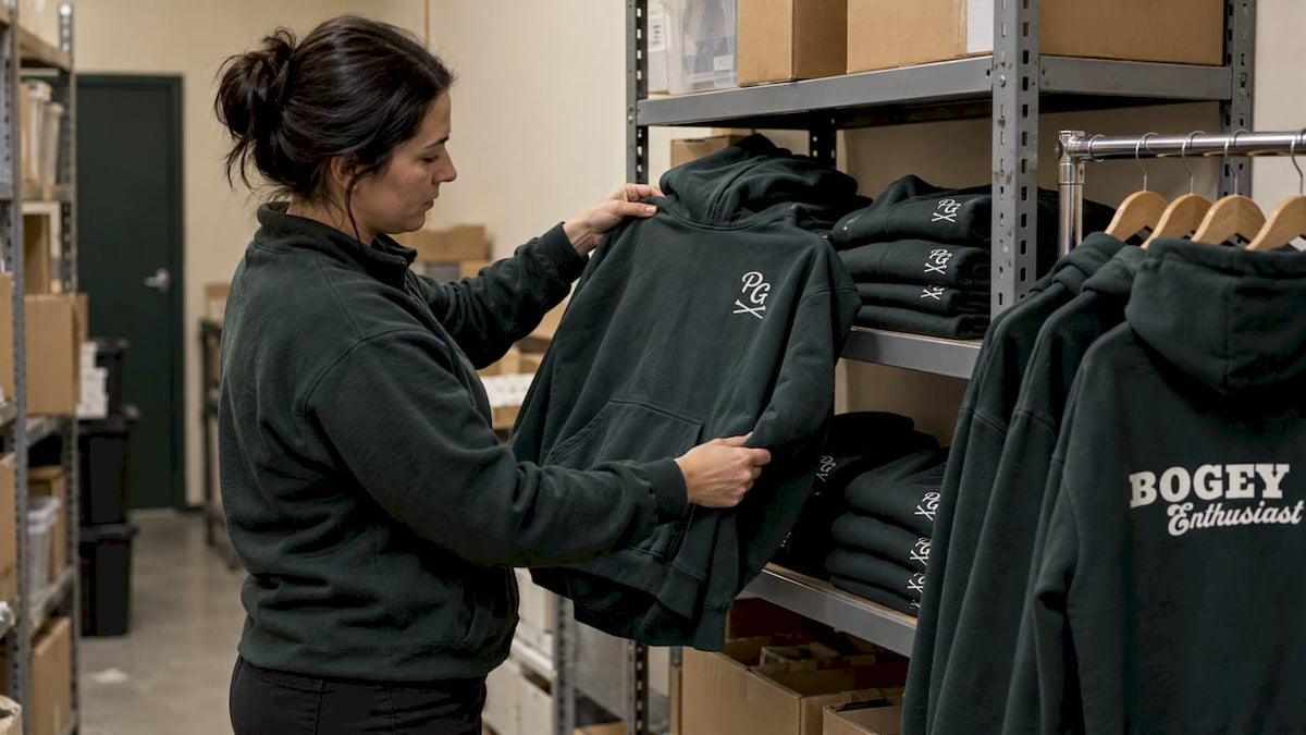 Golf hoodie inventory reviewed in stockroom