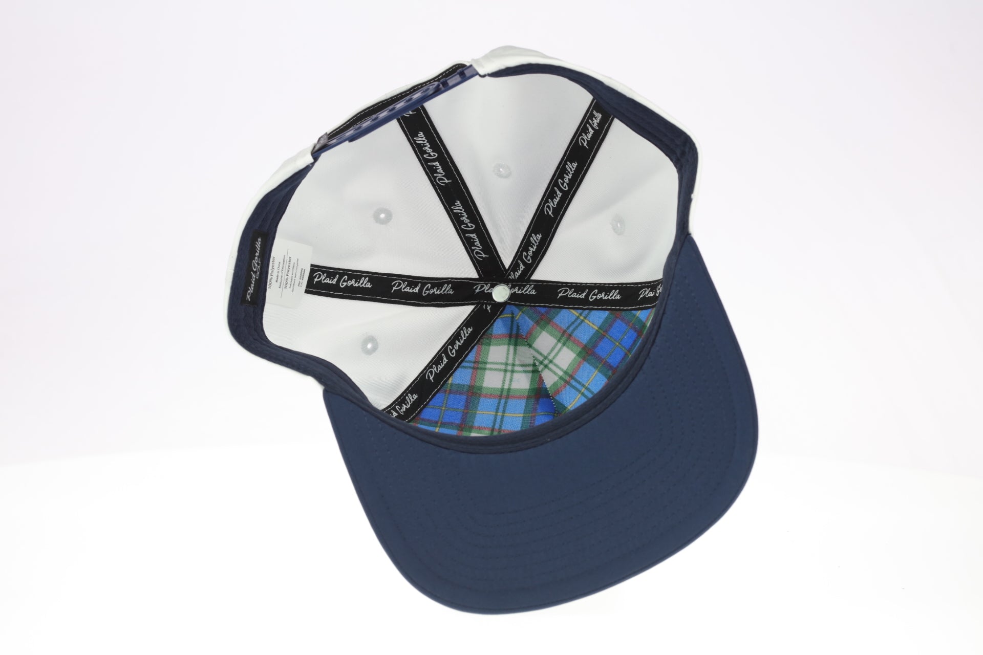 Navy blue cap with white interior and plaid pattern on the brim against a white background